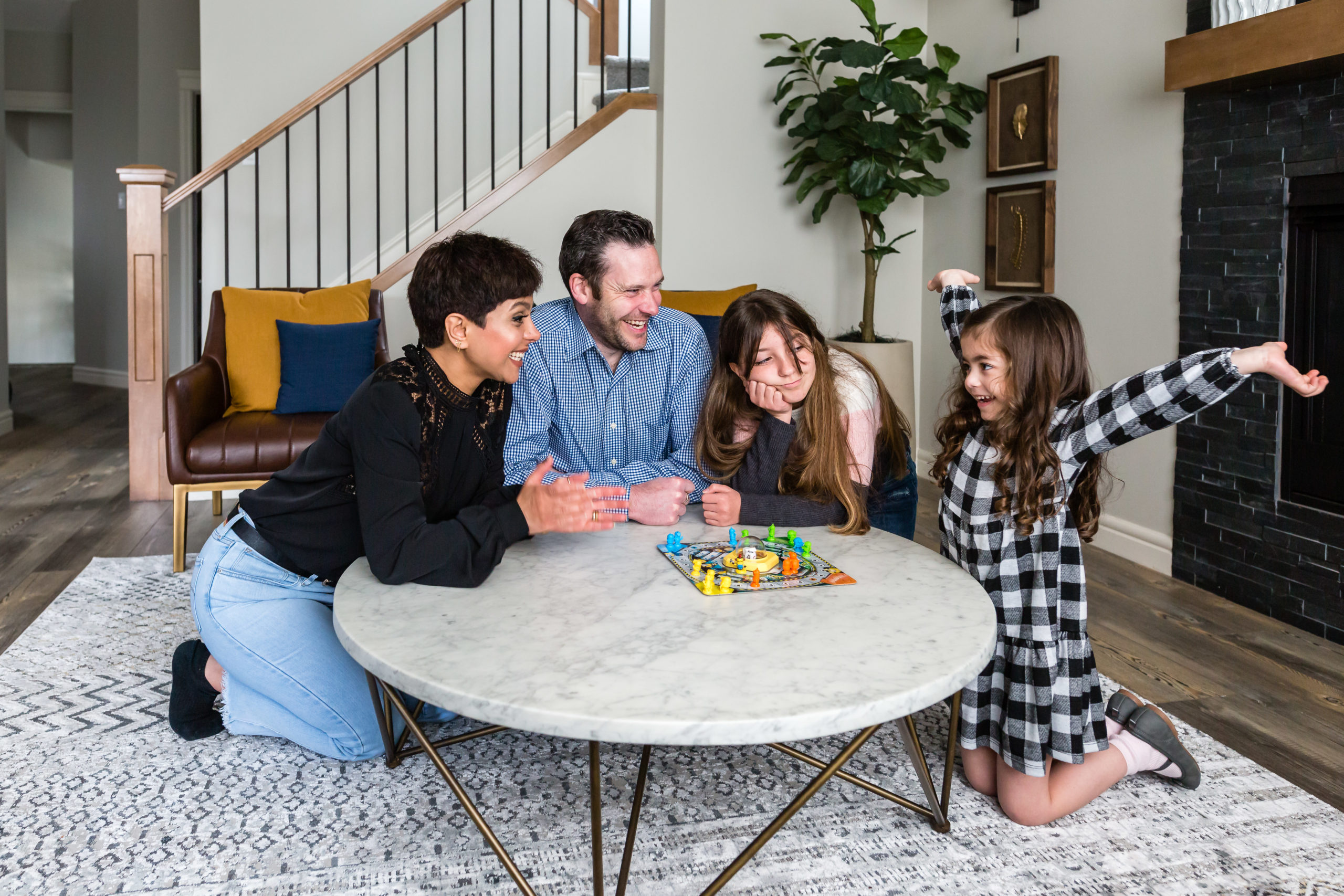 A young family enjoys a board game in the living room of their Pacesetter home.